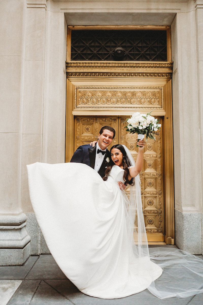 Newly married couple in front of gold door in downtown Chicago.